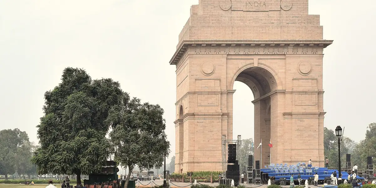 India Gate in Delhi seen from the west, trees to the left.